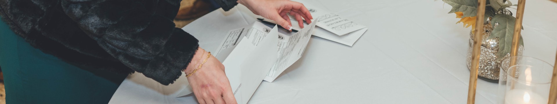 Hands signing a Florida marriage license at a reception table